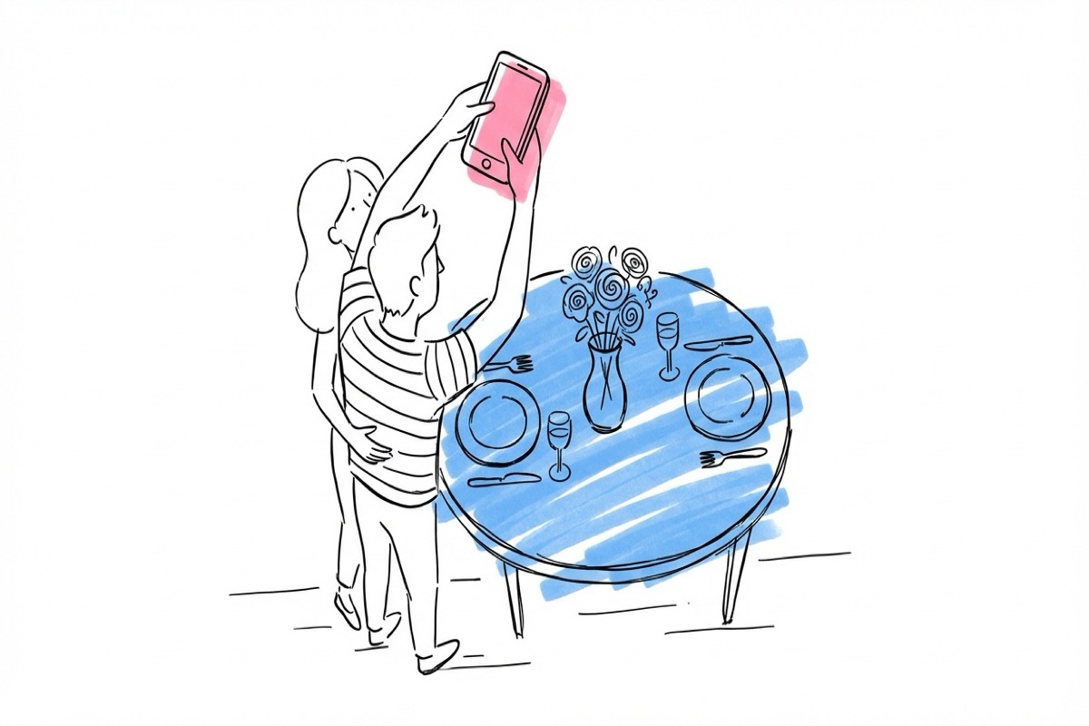 Par som tittar ner på ett fullt dukat provbord hemma, en av dem håller en telefon för att fotografera uppifrån — provdukning